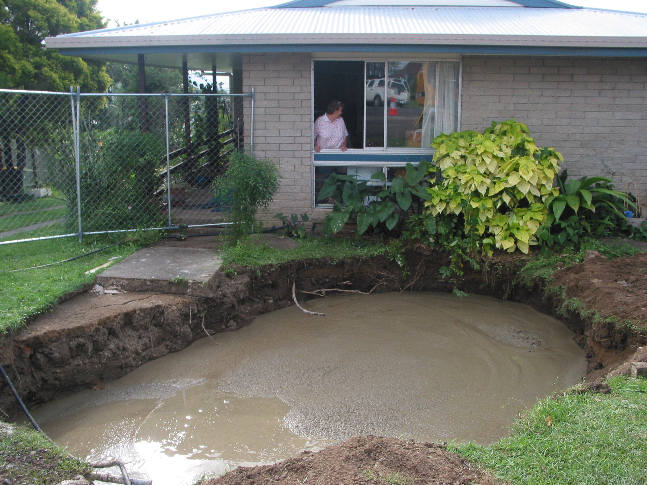 Homeowner looking at subsidence adjacent to their home