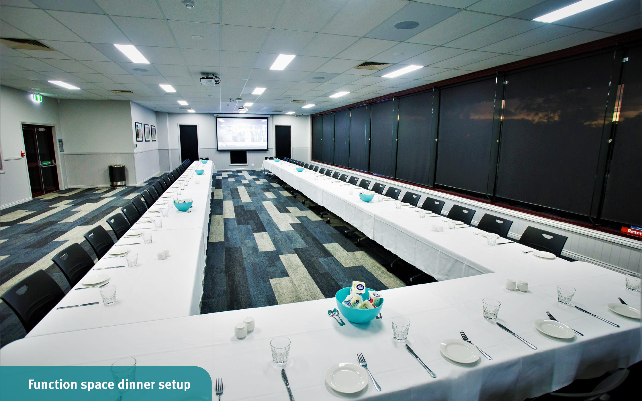 The function room dining tables set in a large u-shape and dinnerware ready for a networking breakfast event at the Toowoomba Sports Grounds.