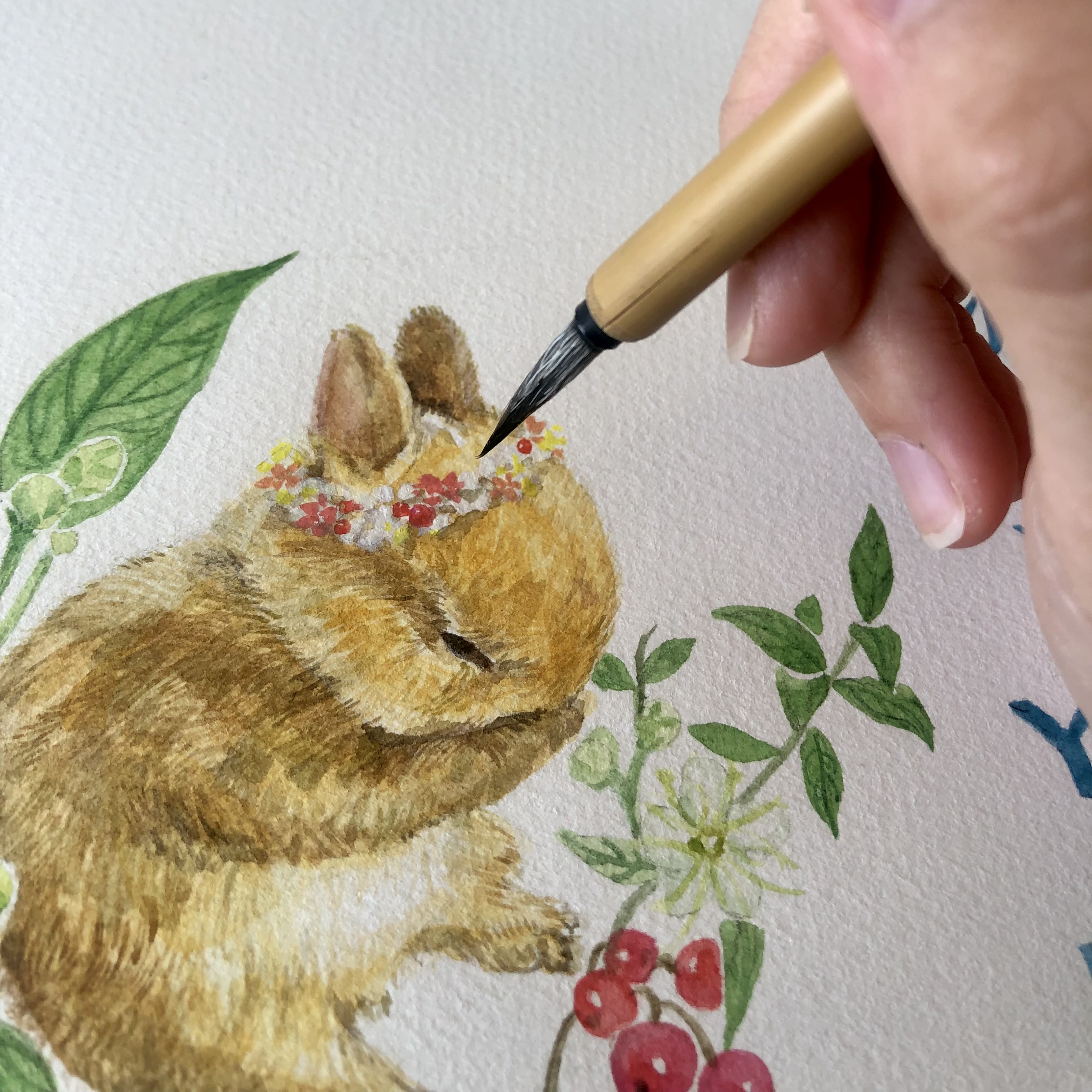 Rabbit painting Artist Silka Huang adding brush strokes to the Year of the Rabbit design