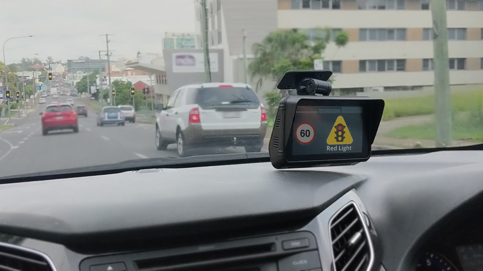Photo of the interior of a car from perspective of driver with steering wheel in the forefront. Shows a small rectangular display attached to the windscreen, with a participant selection menu.
