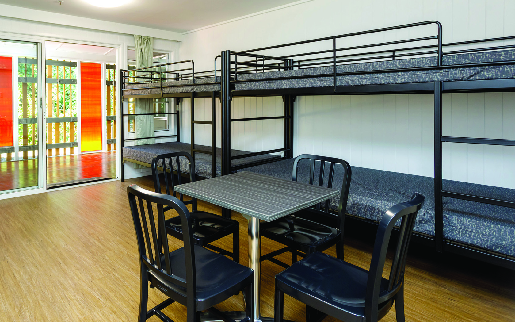 An interior view of room with bunk beds and a table with chairs.