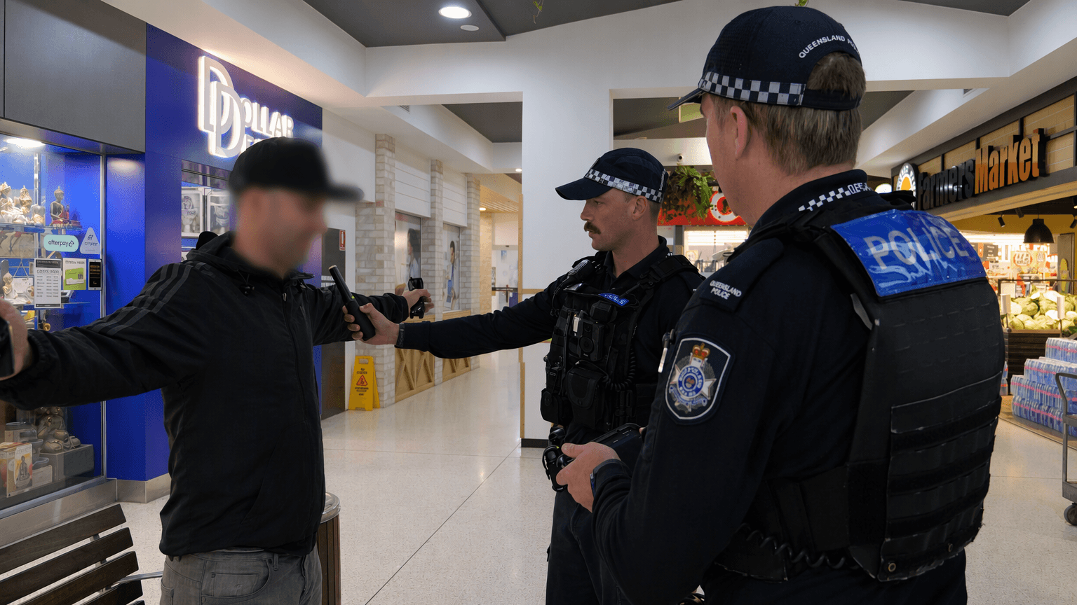 Police officers conducting wanding operation in shopping centre