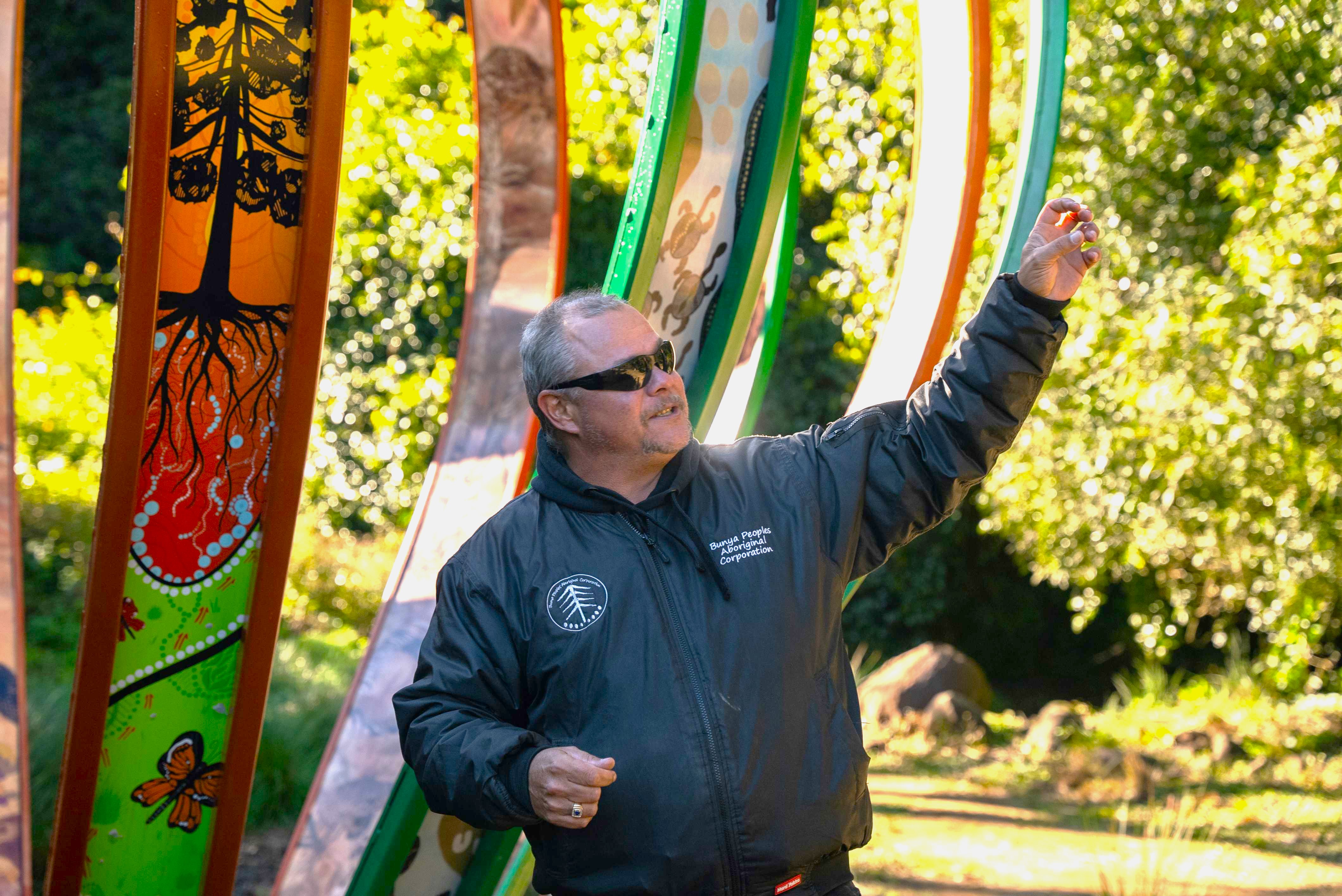Ranger talking in front of outdoor Aboriginal art works