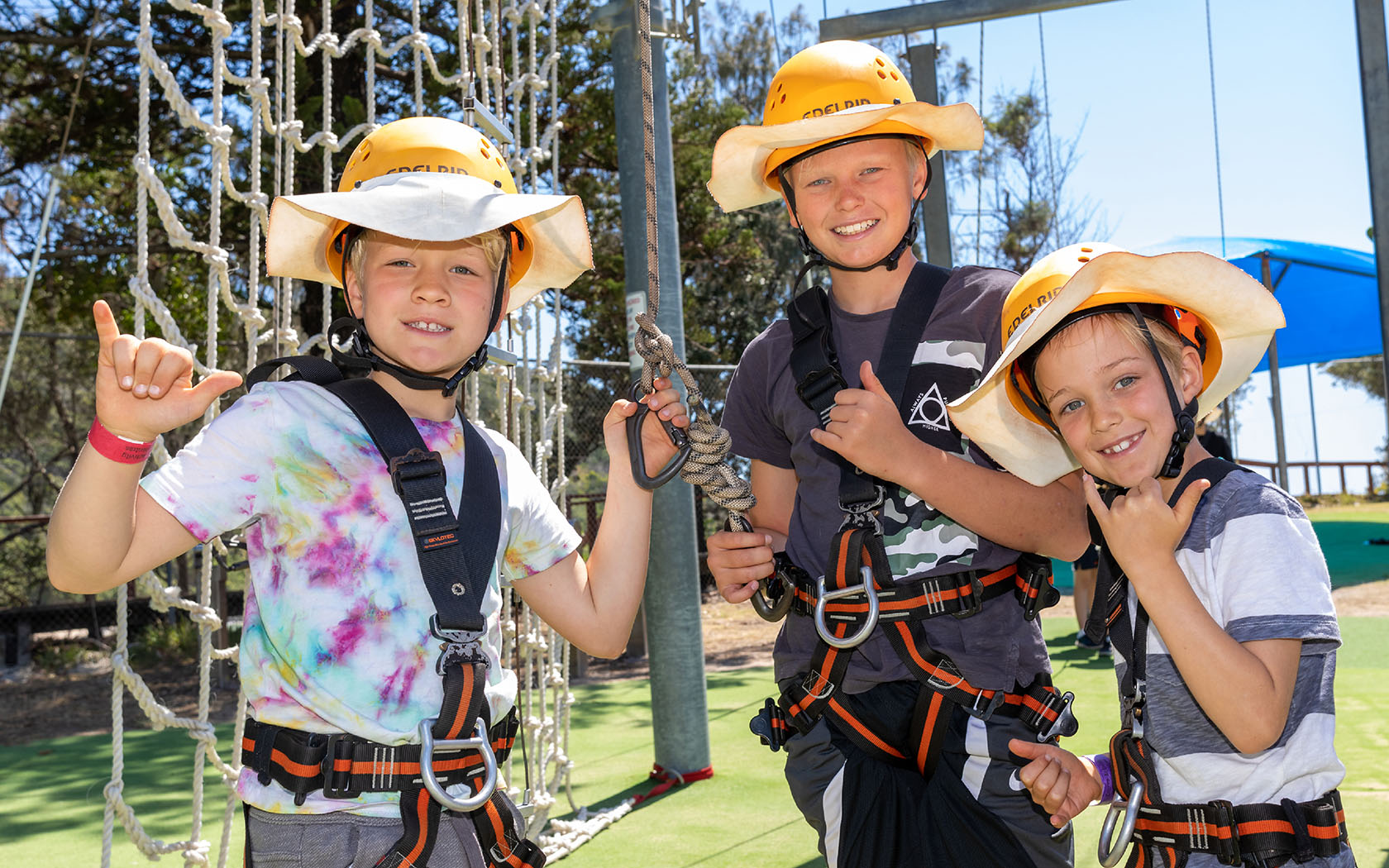 Children wearing safety harnesses at the ropes course.