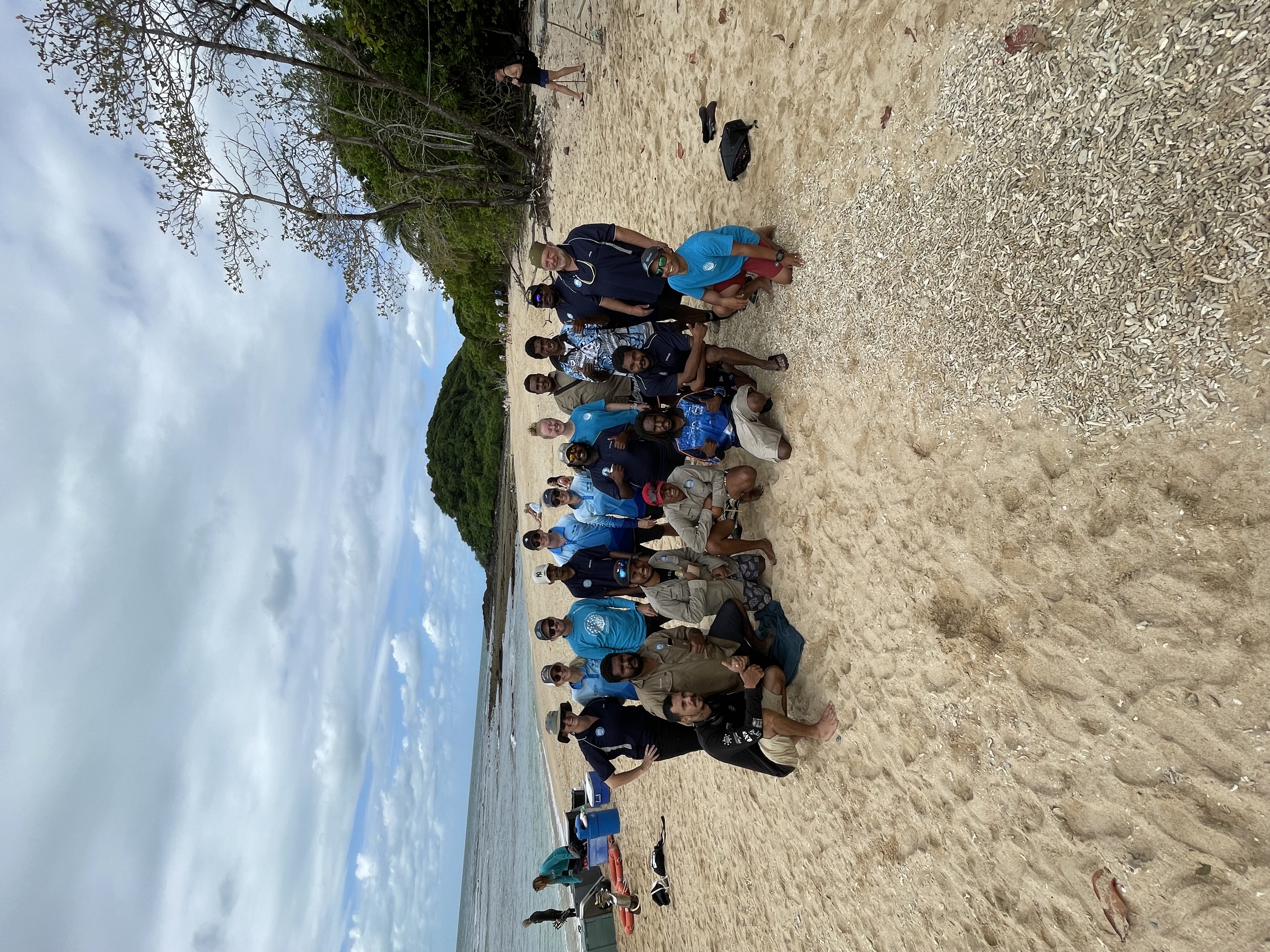 Group of people pose for camera on an island beach