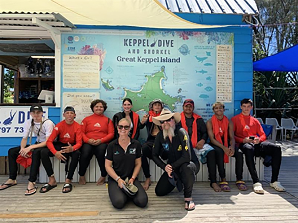 Photo of a group of students sitting outside diver tourism operator facility