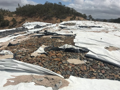 Deteriorated plastic liner on the waste rock stockpile