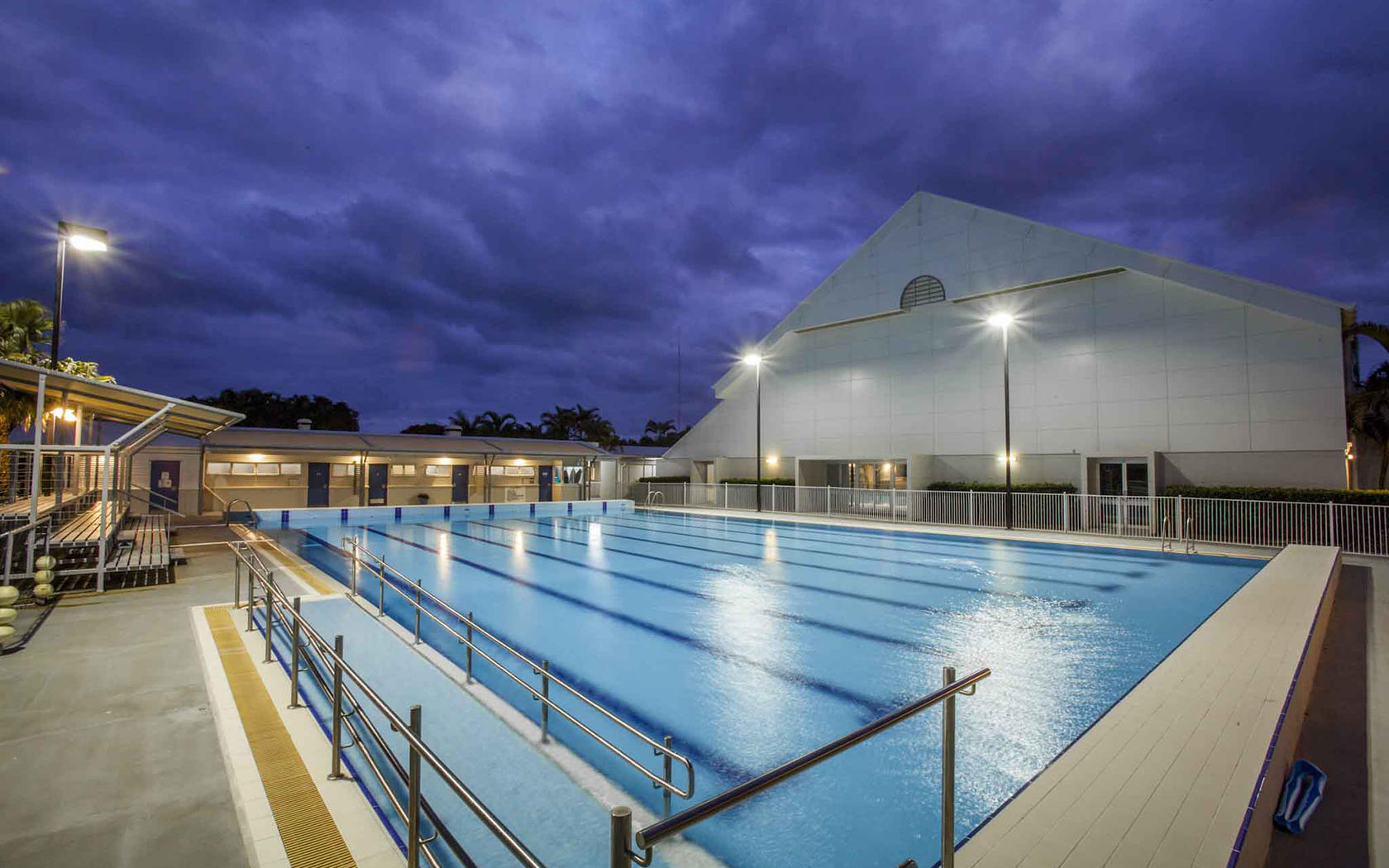 Outdoor lap pool at night time with lights on