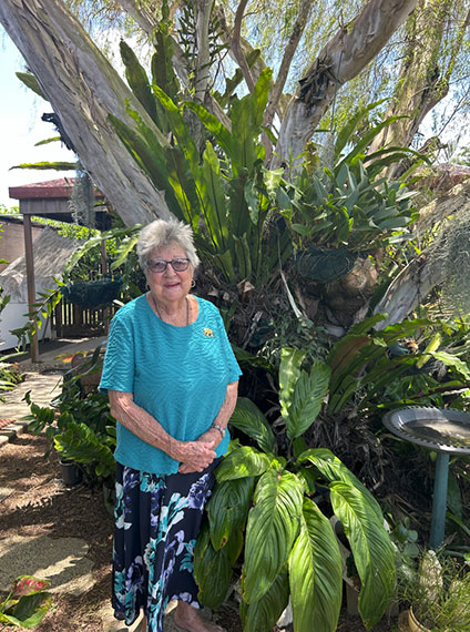 old woman standing in her garden