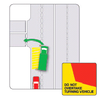 A red car is behind a green truck in the traffic. The yellow areas show the space needed for the truck to turn indicating that it\'s not safe to overtake the turning truck.