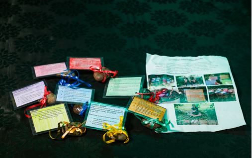 Garden rocks tied with ribbon attached to laminated cards and an A4 page with photos of the rocks in a school garden.