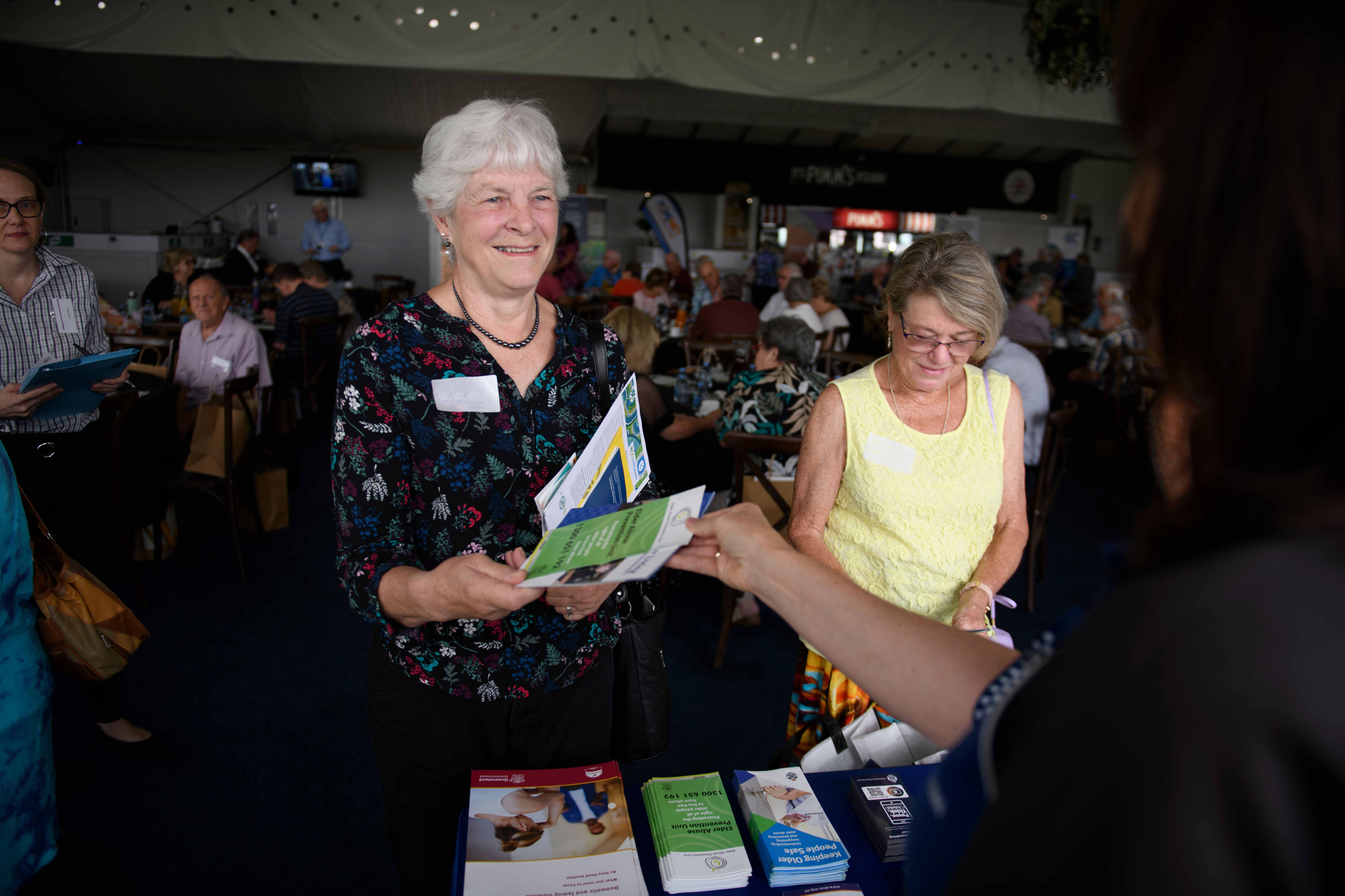 Ladies attending the seniors expo and talking to an exhibitor