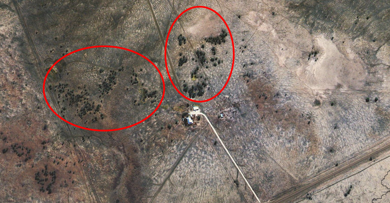 Colour aerial satellite image of a grassland landscape. A small group of building is shown in the middle of the image, and there are some areas of woody vegetation encroaching (circled in red).